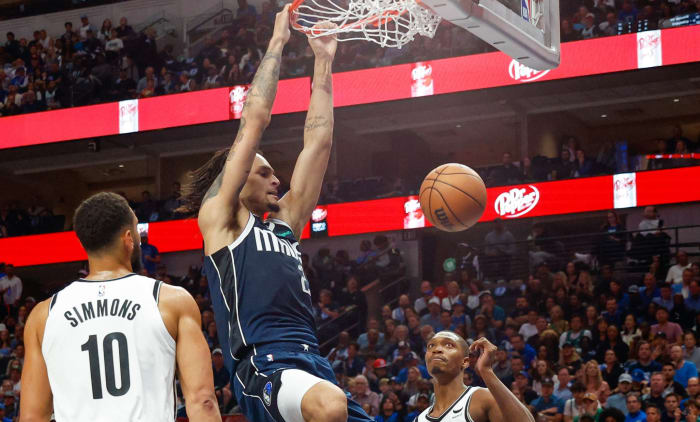 Dereck Lively II slams home a dunk as Ben Simmons and Lonnie Walker IV look on.